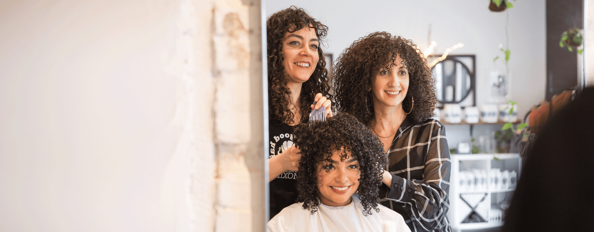 Hairstylist and Original Moxie owner with a client smiling in a mirror