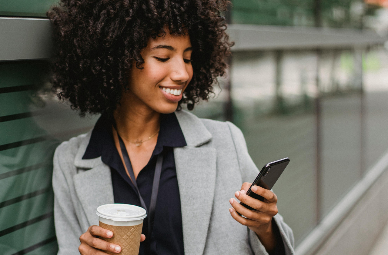 Woman with curly hair holding phone