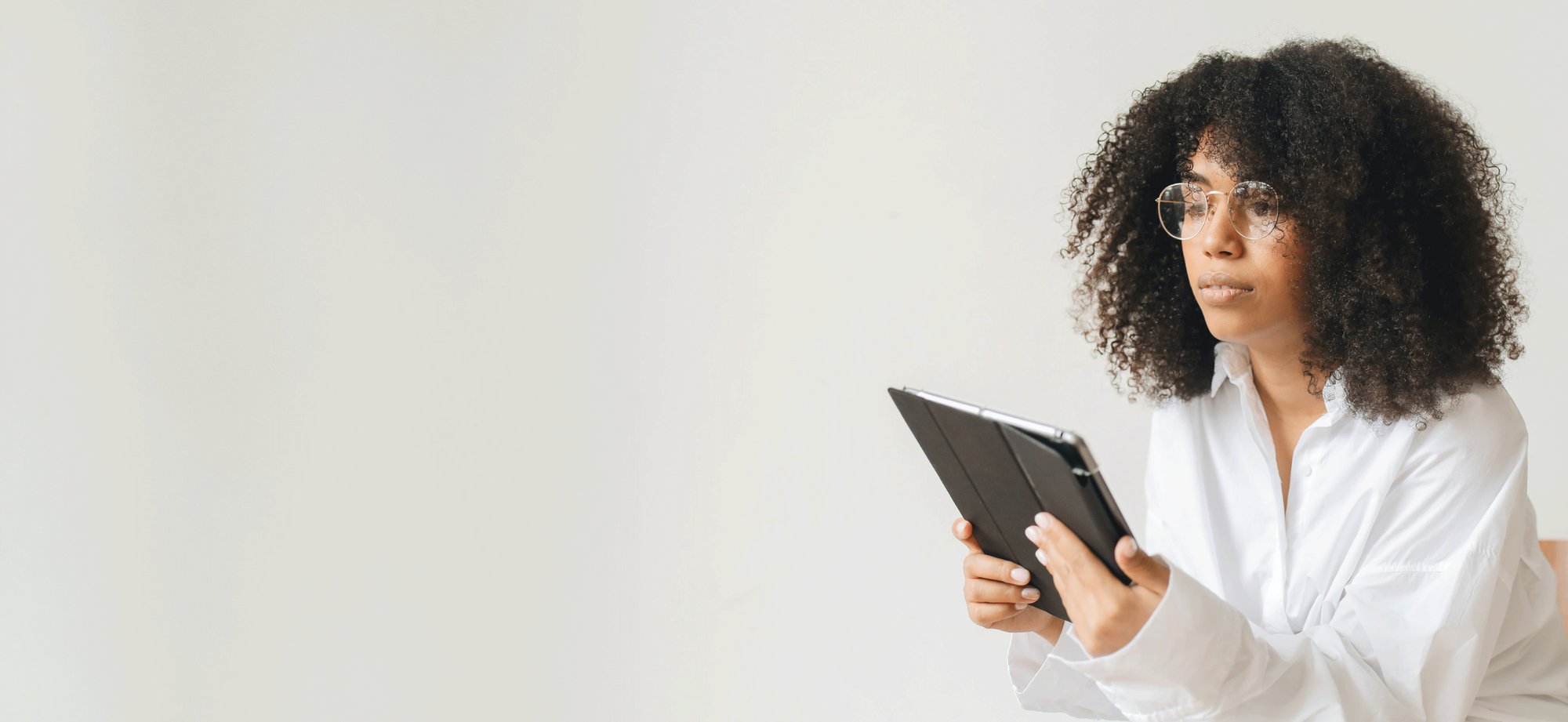 Woman with curly hair using a tablet