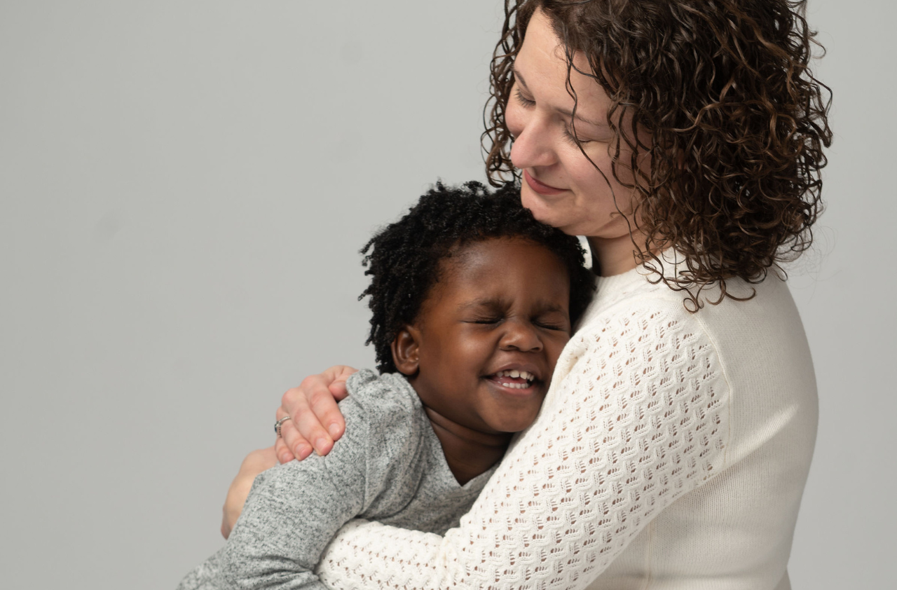 A mother holding her daughter and smiling