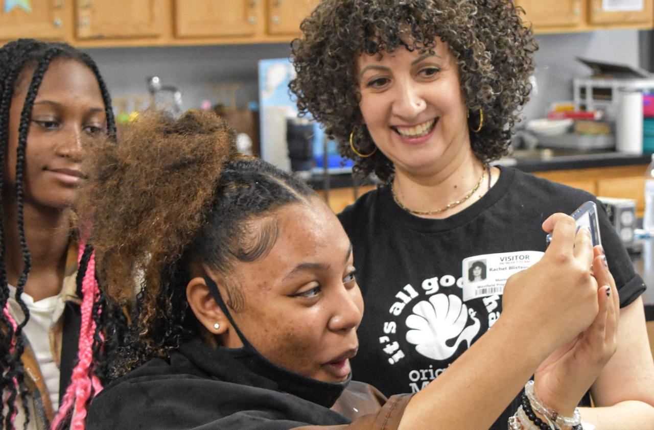 Students at a curly hair education event smiling at their hair